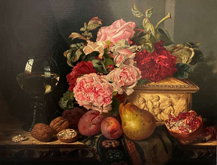 Still life with roses, fruit and a glass of wine on a ledge
